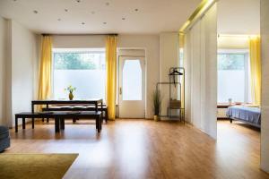 One Bedroom Apartment Berlin Neukölln في برلين: غرفة معيشة مع طاولة وستائر صفراء