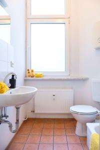 a bathroom with a sink and a toilet and a window at One Bedroom Apartment Berlin Neukölln in Berlin