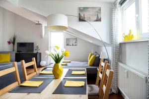 un salon avec une table à manger et un vase jaune dans l'établissement Urban Rooftop Apartment - Berlin MITTE - A C, à Berlin