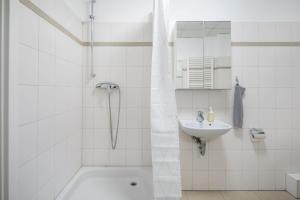 ハンブルクにあるCosy 2 room apartment in Hamburg Hammerbrookの洗面台とシャワー付きの白いバスルーム