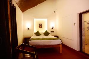 een kleine slaapkamer met een bed in een kamer bij Coorg Mystere - Luxury Homestay in Madikeri