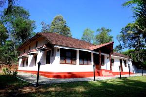 a house in the middle of a field at Coorg Mystere - Luxury Homestay in Madikeri