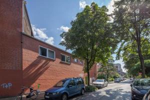 a blue van parked next to a brick building at Schulterblatt-Apartments Hamburg Unit 3 For 5 in Hamburg