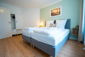 1 dormitorio con 1 cama grande con sábanas blancas en Hamburg City Apartment for 7 en Hamburgo
