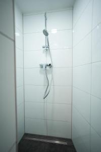 una ducha con cabezal de ducha en una pared blanca en Hamburg City Apartment for 7 en Hamburgo