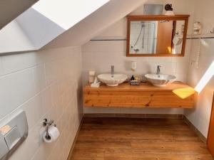 a bathroom with two sinks and a mirror at Posthotel Arnold in Gunzenhausen