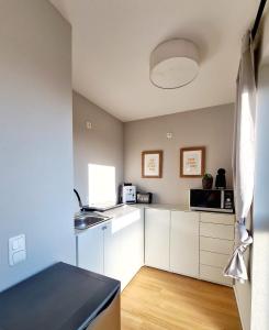 une cuisine avec des armoires blanches et un comptoir noir dans l'établissement Urban Living - Top Floor Apartment, à Hambourg
