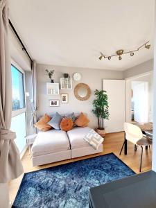 a living room with a white couch and a blue rug at Urban Living - Top Floor Apartment in Hamburg