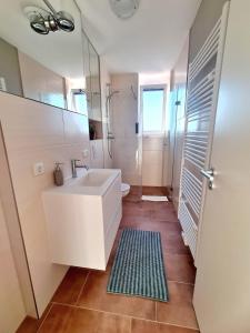 y baño blanco con lavabo y ducha. en Urban Living - Top Floor Apartment, en Hamburgo