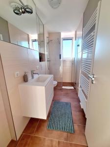 une salle de bain blanche avec un lavabo et une douche dans l'établissement Urban Living - Top Floor Apartment, à Hambourg