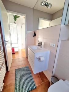 Baño blanco con lavabo y espejo en Urban Living - Top Floor Apartment, en Hamburgo