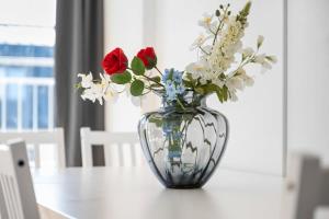 a glass vase with flowers in it on a table at Munich Gem - 2 Bedroom Alpine View Tranquility in Munich