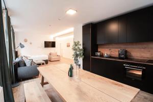 uma cozinha com uma mesa de madeira e uma sala de estar em Hamburg Gem for 12 em Hamburgo