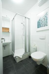 a white bathroom with a shower and a toilet at Hamburg City Center Apartment in Hamburg