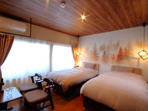 una camera d'albergo con due letti e una finestra di みつまたロッヂ a Yuzawa