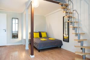 - une chambre avec un lit et des oreillers jaunes dans l'établissement Stylish Loft Apartment plus SelfCheckIn plus Street Parking, à Berlin
