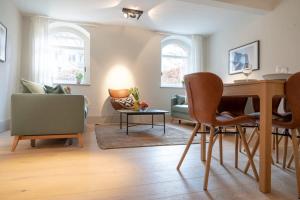 sala de estar con sofá, mesa y sillas en Spacious 3-bedroom apartment near Eilbekpark en Hamburgo