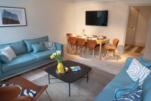 uma sala de estar com um sofá azul e uma mesa em Spacious 3-bedroom apartment near Eilbekpark em Hamburgo