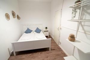 um quarto com uma cama branca e almofadas azuis em Great Three Bedroom Apartment em Hamburgo