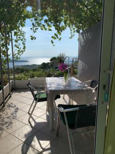 a table and chairs on a patio with a view of the ocean at Apartments Jaca in Rab