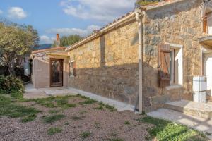 une ancienne maison en pierre avec un mur en pierre dans l'établissement Casa Calma - Maison à proximité des plages, à Figari