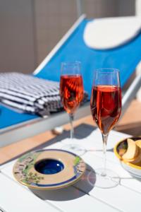 Donna Luisa Suites 19 Amalfi view - free parking في Pontone: كأسين من النبيذ الأحمر يجلسون على الطاولة