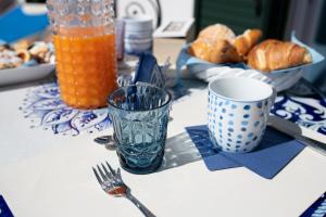 stół z talerzami jedzenia i szklanką soku pomarańczowego w obiekcie Donna Luisa Suites 19 Amalfi view - free parking w mieście Pontone