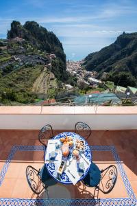 una mesa con un plato de comida en el balcón en Donna Luisa Suites 19 Amalfi view - free parking, en Pontone