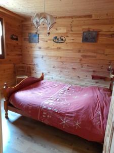 Bett in einem Zimmer mit einer Holzwand in der Unterkunft Gîte le Clapier in Theys