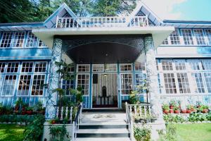 una casa blu e bianca con portico di The Heritage Shimla by Boho Stays a Shimla