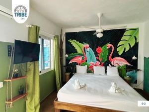 um quarto com uma cama com um mural de flamingos em Tribe Bayahibe em Bayahibe