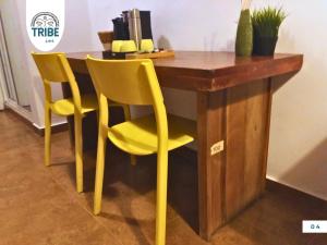 escritorio con 2 sillas amarillas y mesa en Tribe Bayahibe, en Bayahibe