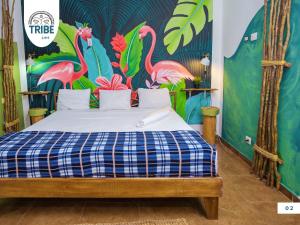 ein Schlafzimmer mit einem Bett und einem Wandbild von Flamingos in der Unterkunft Tribe Bayahibe in Bayahibe