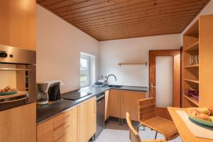 a kitchen with wooden cabinets and a wooden ceiling at Ferienwohnung Bergpanorama in Oberaudorf
