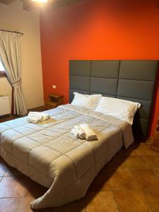 una camera da letto con un grande letto con asciugamani di La corte dell'ulivo a Polazzo
