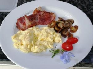 a white plate with scrambled eggs and mushrooms and tomatoes at Bydand Guest House in Addo