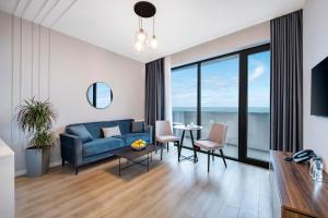 a living room with a blue couch and a table at STEPS Batumi Hotel & Suites in Batumi