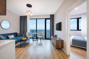 STEPS Batumi Hotel & Suites في باتومي: غرفة في الفندق مع أريكة زرقاء وسرير وطاولة