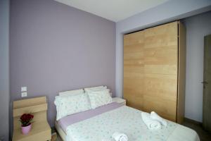 a small bedroom with a bed and a wooden headboard at See to Sea Apartments 2 in Paralia Dionysiou