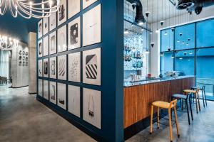 a bar in a restaurant with blue walls and stools at STEPS Batumi Hotel & Suites in Batumi