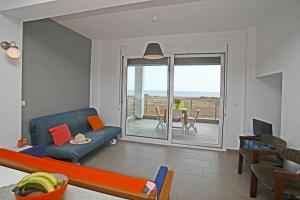 a living room with a couch and a view of the ocean at See to Sea Apartments 2 in Paralia Dionysiou