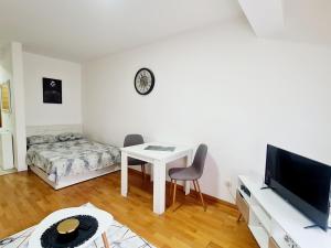 een woonkamer met een tafel, een tv en een bed bij RELAX LuX 2 in Jagodina