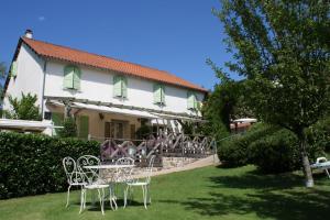 un gruppo di sedie e un tavolo di fronte a una casa di Auberge La Tomette, The Originals Relais a Vitrac