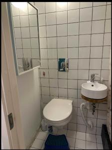 La petite salle de bains est pourvue de toilettes et d'un lavabo. dans l'établissement B & E Apartment, à Huddinge