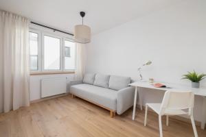 uma sala de estar branca com um sofá e uma mesa em Adorable Apartment in the Centre of Katowice by Renters em Katowice