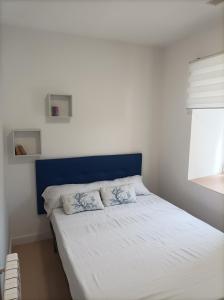 Bett mit blauem Kopfteil in einem Schlafzimmer in der Unterkunft Casa Cabárceno in Santiago