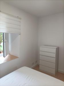 Habitación blanca con cama y ventana en Casa Cabárceno, en Santiago