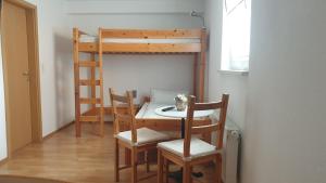einen Tisch und Stühle in einem Zimmer mit Etagenbett in der Unterkunft Gästehaus Sibylle in Rust