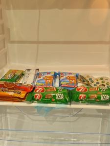 a refrigerator filled with different types of snacks at بيت الجود للأجنحة المفروشة in Sīdī Ḩamzah