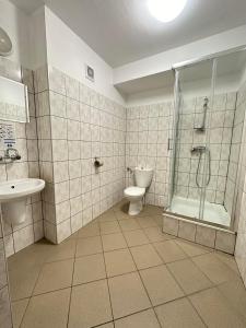 a bathroom with a toilet and a shower and a sink at Ząbkowickie Centrum Sportu i Rekreacji Sp. z o. o. in Ząbkowice Śląskie